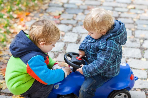 Två småbarn pojkar leker med bil i park — Stockfoto