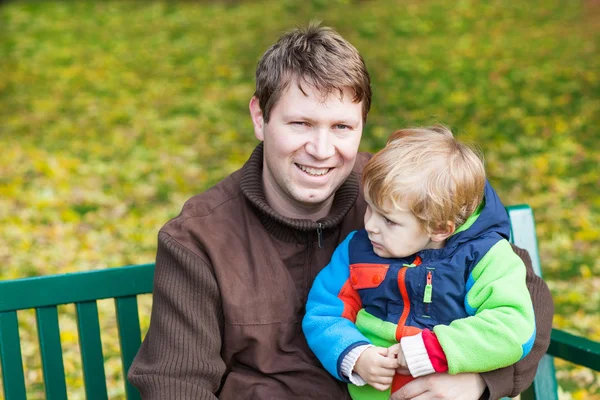 Mladík otce a batole v podzimním parku — Stock fotografie