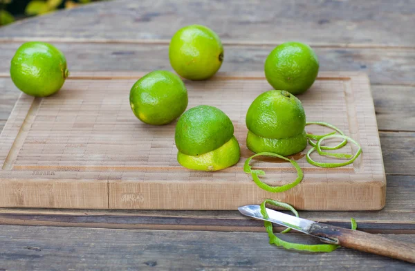 Limes verde fresco su vecchio tavolo di legno — Foto Stock