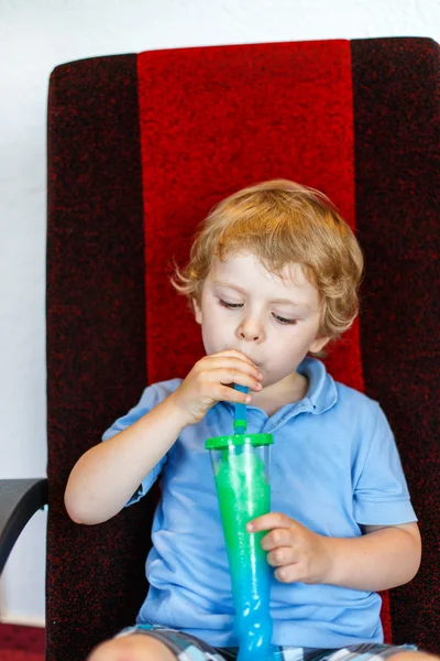 Kleiner Junge trinkt buntes gefrorenes Schneematsch-Eis — Stockfoto