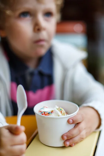 Adorável menino comendo sorvete de iogurte congelado no café — Fotografia de Stock