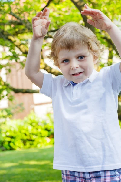 Porträtt av leende glad liten pojke i trädgården — Stockfoto