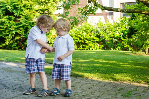 Zwei kleine Geschwister, die sich im Familienlook draußen amüsieren — Stockfoto