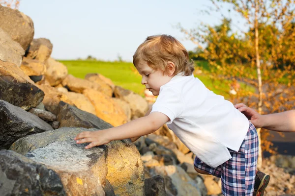 Little boy climbing outdoors on summer evening — Stock Photo, Image