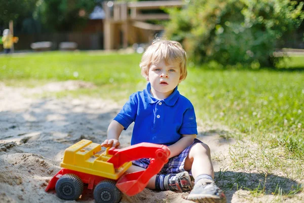 Menino criança brincando com areia e brinquedo no playground — Fotografia de Stock
