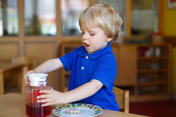 Zweijähriger kleiner Junge frühstückt im Kinderzimmer — Stockfoto