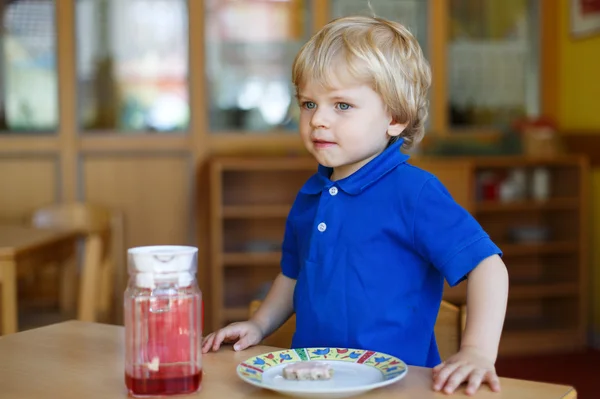 Petit garçon de deux ans déjeunant à la crèche — Photo