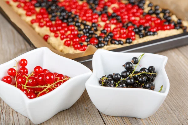 Red and black currant berries with home baked cake on background — Stock Photo, Image