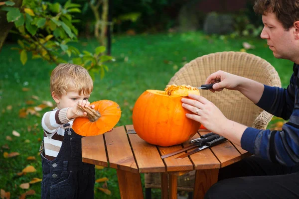 Jovem e criança menino fazendo abóbora halloween — Fotografia de Stock