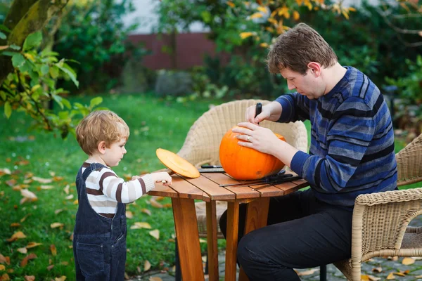 Mladý muž a batole chlapec díky halloween dýně — Stock fotografie