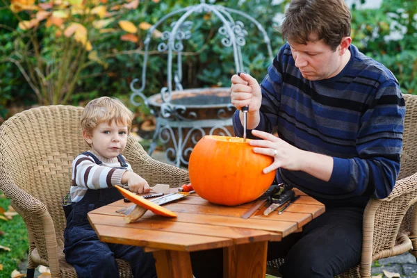 Young man and toddler boy making halloween pumpkin — Stock Photo, Image