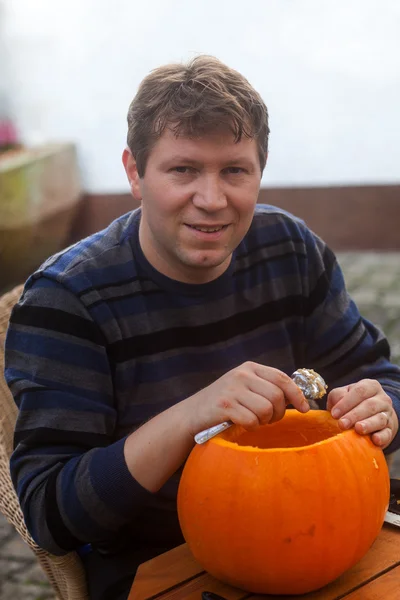 Young man making halloween pumpkin — Stock Photo, Image