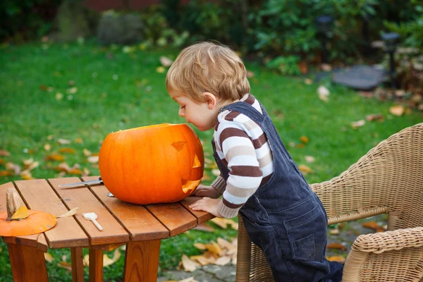 Schattig peuter jongen met halloween pompoen — Stockfoto