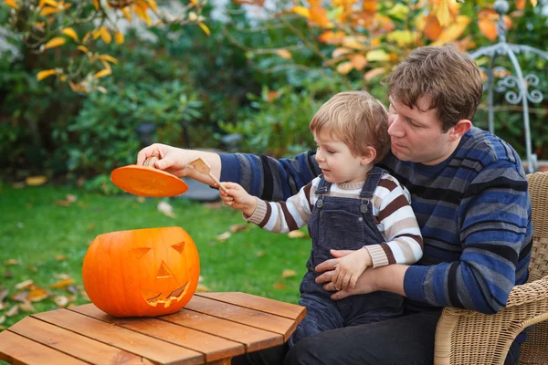 Jeune homme et tout-petit garçon faisant citrouille halloween — Photo