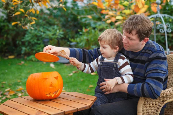 Mladý muž a batole chlapec díky halloween dýně — Stock fotografie