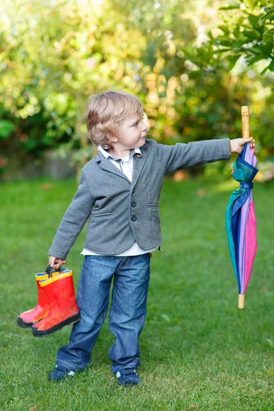 Little cute toddler boy with colorful umbrella and boots, outdoo — Stock Photo, Image
