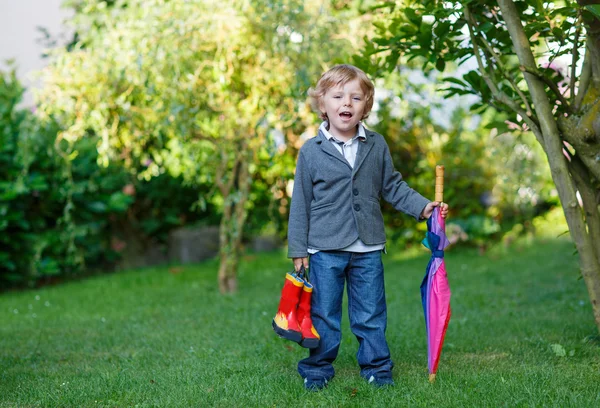 Little cute toddler boy with colorful umbrella and boots, outdoo — Stock Photo, Image