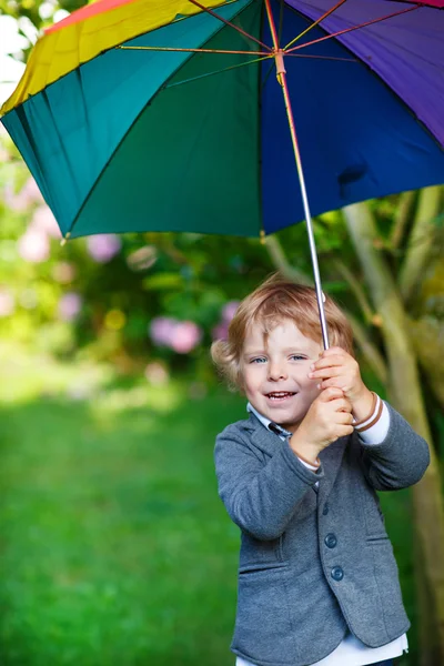 Piccolo ragazzo bambino carino con ombrello colorato e stivali, outdoo — Foto Stock