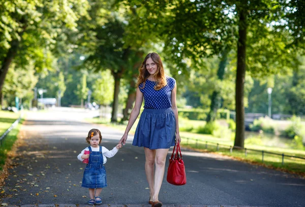 Schöne Mutter und kleine Tochter spazieren im Sommerpark — Stockfoto