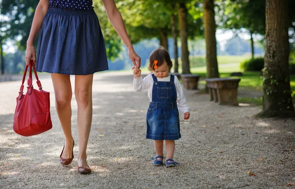 Kleines Mädchen spaziert mit schöner Mutter im Sommerpark — Stockfoto