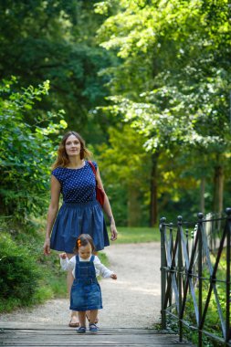 güzel anne ve küçük kızı yaz parkta yürüyüş