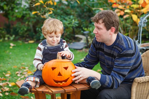Jovem e criança menino fazendo abóbora halloween — Fotografia de Stock