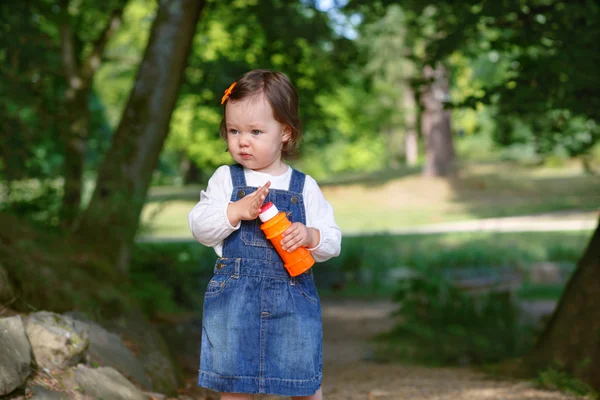 Piccola ragazza carina che gioca con le bolle di sapone nel parco estivo — Foto Stock
