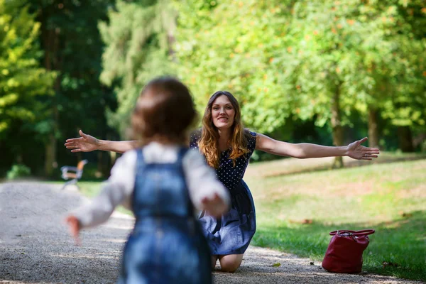 Schöne Mutter und kleine Tochter spazieren im Sommerpark — Stockfoto