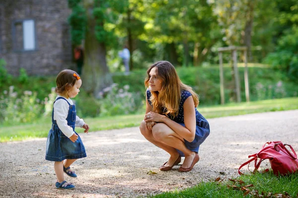 Vacker mor och dotter går i sommar park — Stockfoto