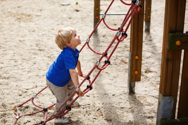 Menino criança sentada no parque infantil — Fotografia de Stock