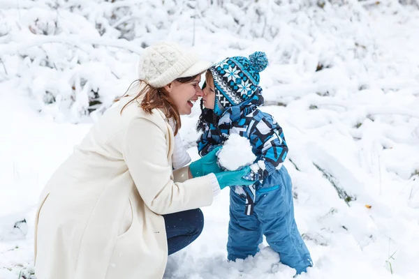 Mor och barn pojke att ha kul med snö på vinterdag — Stockfoto