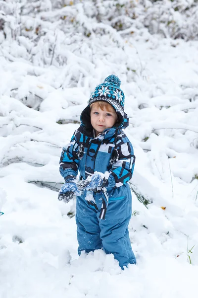 Adorable niño que se divierte con la nieve en el día de invierno — Foto de Stock