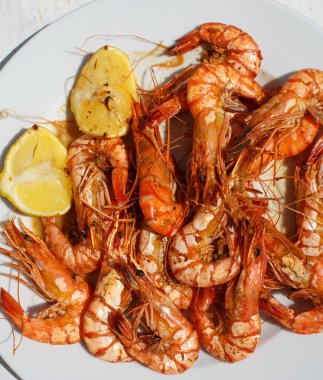 limon ile beyaz tabakta sıcak ızgara siyah kaplan karides