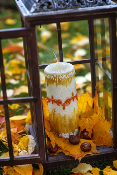 Starožitné Lucerna s podzimním listím a svíčka — Stock fotografie