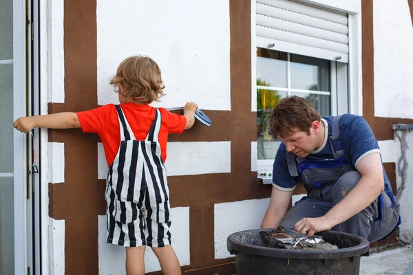 Mały chłopiec malucha pomagał ojcu z remontu domu — Zdjęcie stockowe