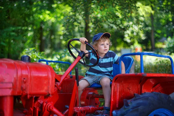 Portret blond chłopca w ciągnik w lecie — Zdjęcie stockowe