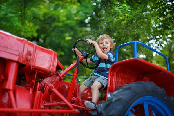 Porträtt av lilla blonda pojken i traktorn i sommar — Stockfoto