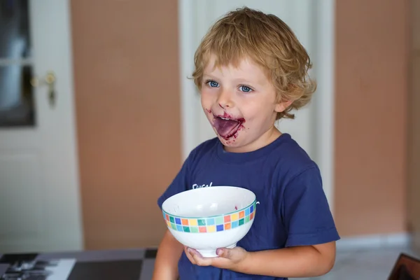 Menino pequeno com rosto sujo comendo mirtilo fresco — Fotografia de Stock