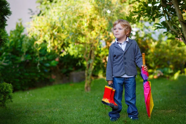 Petit garçon tout-petit mignon avec parapluie coloré et bottes, outdoo — Photo