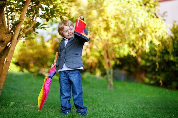 Pequeno menino bonito da criança com guarda-chuva colorido e botas, outdoo — Fotografia de Stock