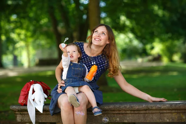 Bella madre e piccola figlia a piedi nel parco estivo — Foto Stock