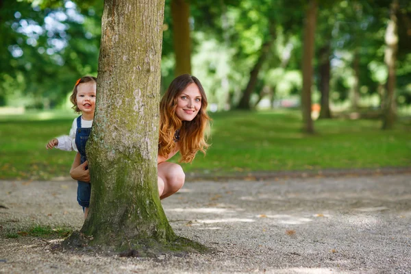 Mooie moeder en kleine dochter wandelen in de zomer park — Stockfoto