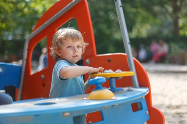 küçük çocuk eğleniyor şehir oyun parkında güneşli günde