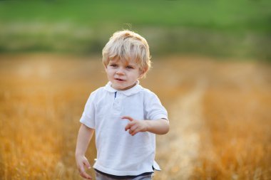 güzel sarışın küçük çocuk sarı saman sahada eğleniyor