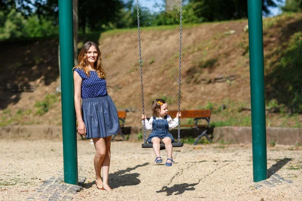 Beautiful mother and little daughter on playground — Stock Photo, Image