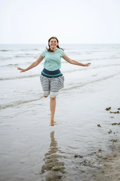 Gelukkig jongedame wandelen op het strand van st.peter ording, Noord — Stockfoto