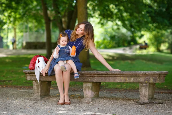 Мать с маленькой дочкой гуляют в летнем парке — стоковое фото
