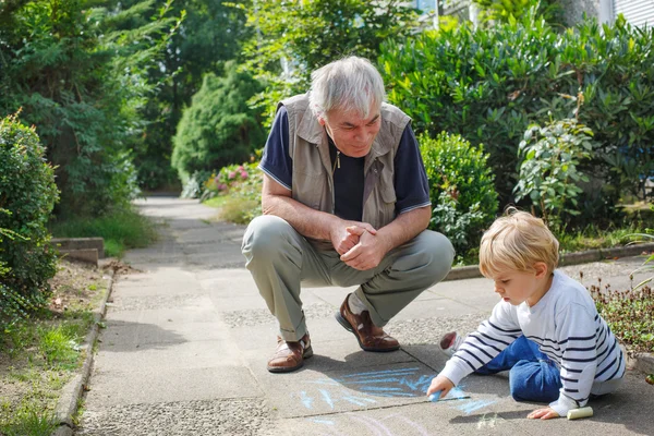 Little blond toddler boy and happy grandfather painting with cha — Stock Photo, Image