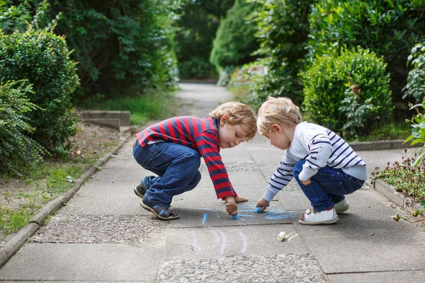 Dois meninos irmãos pintando com giz ao ar livre — Fotografia de Stock