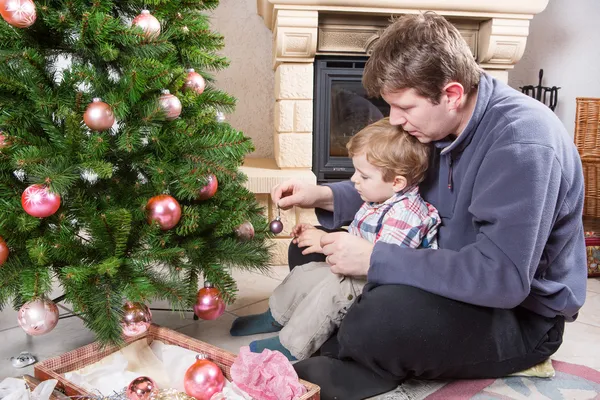 Vader en zoontje versieren kerstboom thuis — Stockfoto